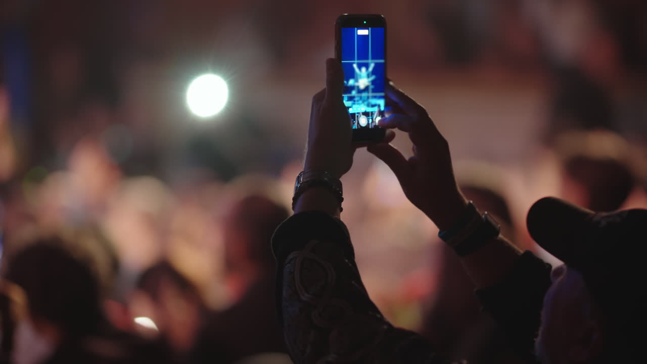 Membro del pubblico che registra un concerto dal vivo con lo smartphone
