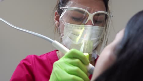 mujer en el higienista dental recibiendo blanqueamiento dental profesional y limpieza por ultrasonido. filmado en 4k
