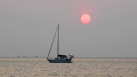 hermoso sol grande sobre un yate en el horizonte durante una puesta de sol en bangsaray cerca de pattaya en tailandia