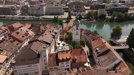 aerial - red tiled roofs circle clocktower and wooden bridge in olten solothurn switzerland