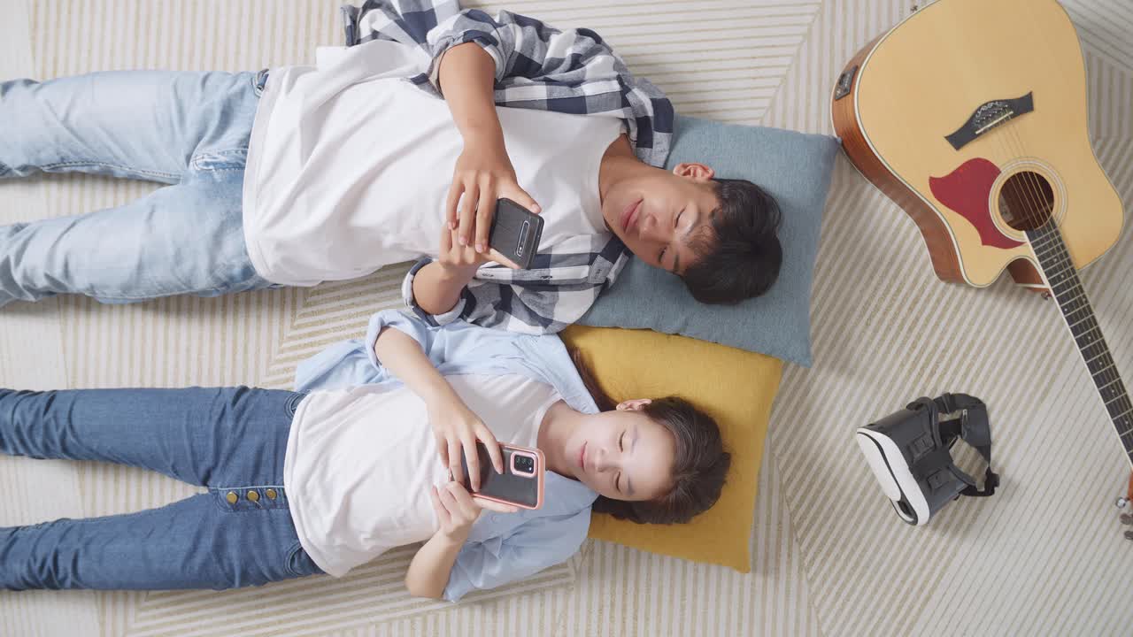 부부는 집에서 휴식을 취하고 스마트폰을 사용합니다.