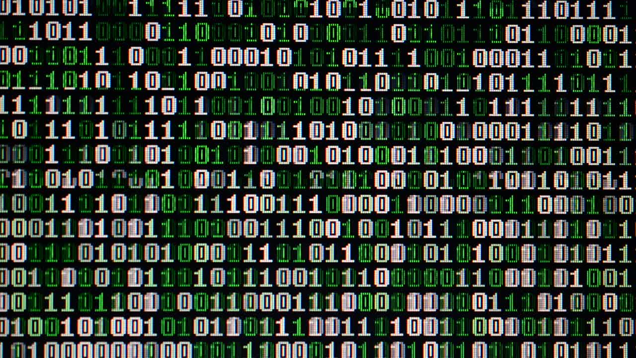 Binary code on the monitor screen. Shooting of a binary code, background