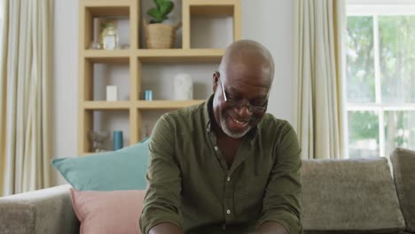 Retrato-De-Un-Hombre-Afroamericano-Sonriente-Haciendo-Videollamadas-En-La-Sala-De-Estar