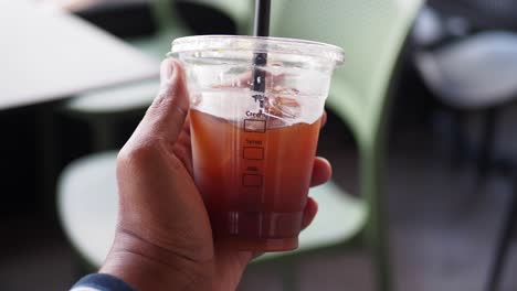 man holding a cup of iced coffee