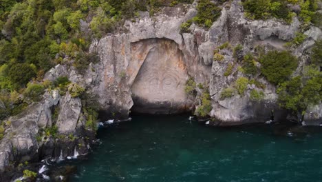 Spektakuläres-Tätowiertes-Maori-Gesicht,-Das-In-Eine-Felsige-Klippe-Gehauen-Ist