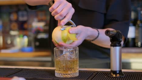 a skilled bartender demonstrates mixology by preparing whiskey cocktails, featuring fresh lemon peels, ripe pears, and crisp apples in each drink