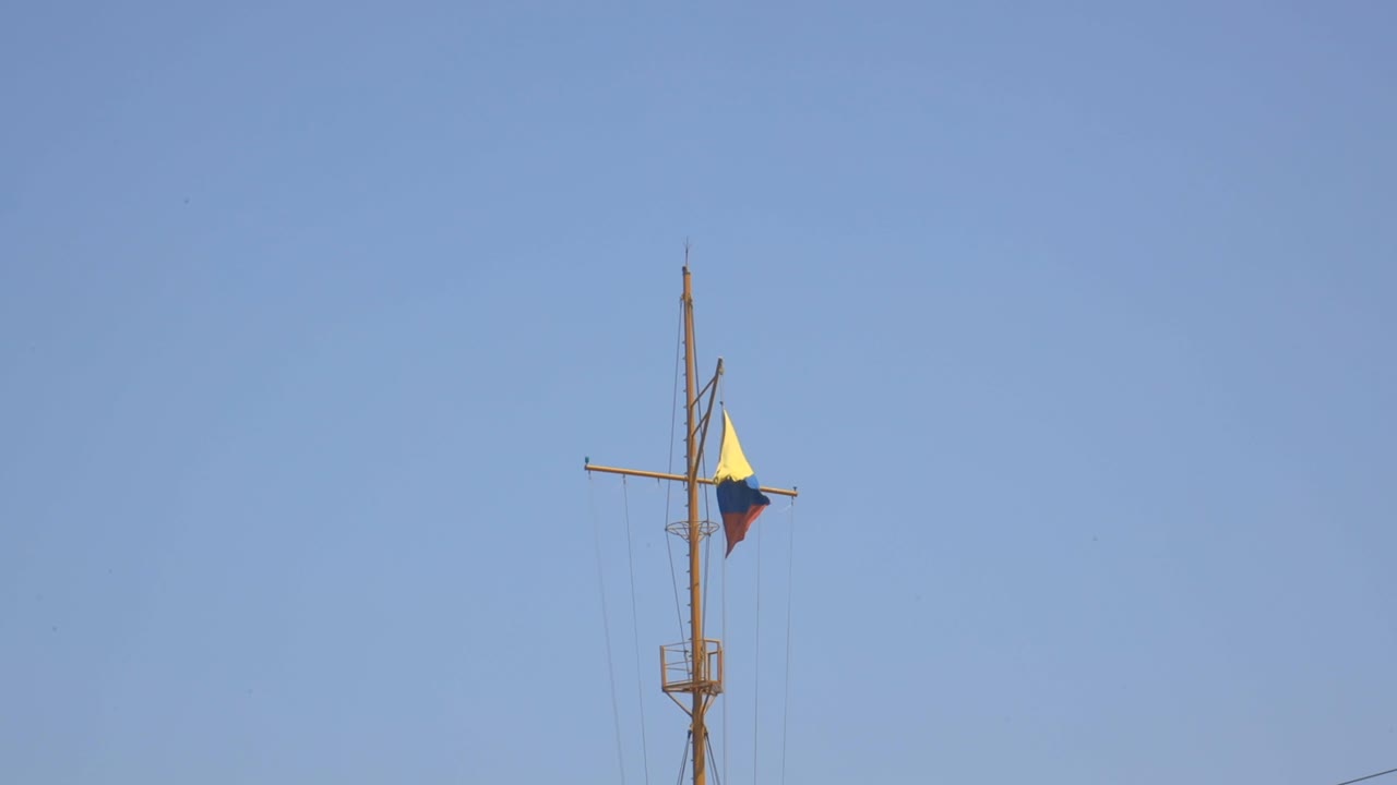 Bendera nasional Kolombia berkibar di tiang kapal dengan langit cerah berwarna kuning, biru, merah di Amerika Selatan