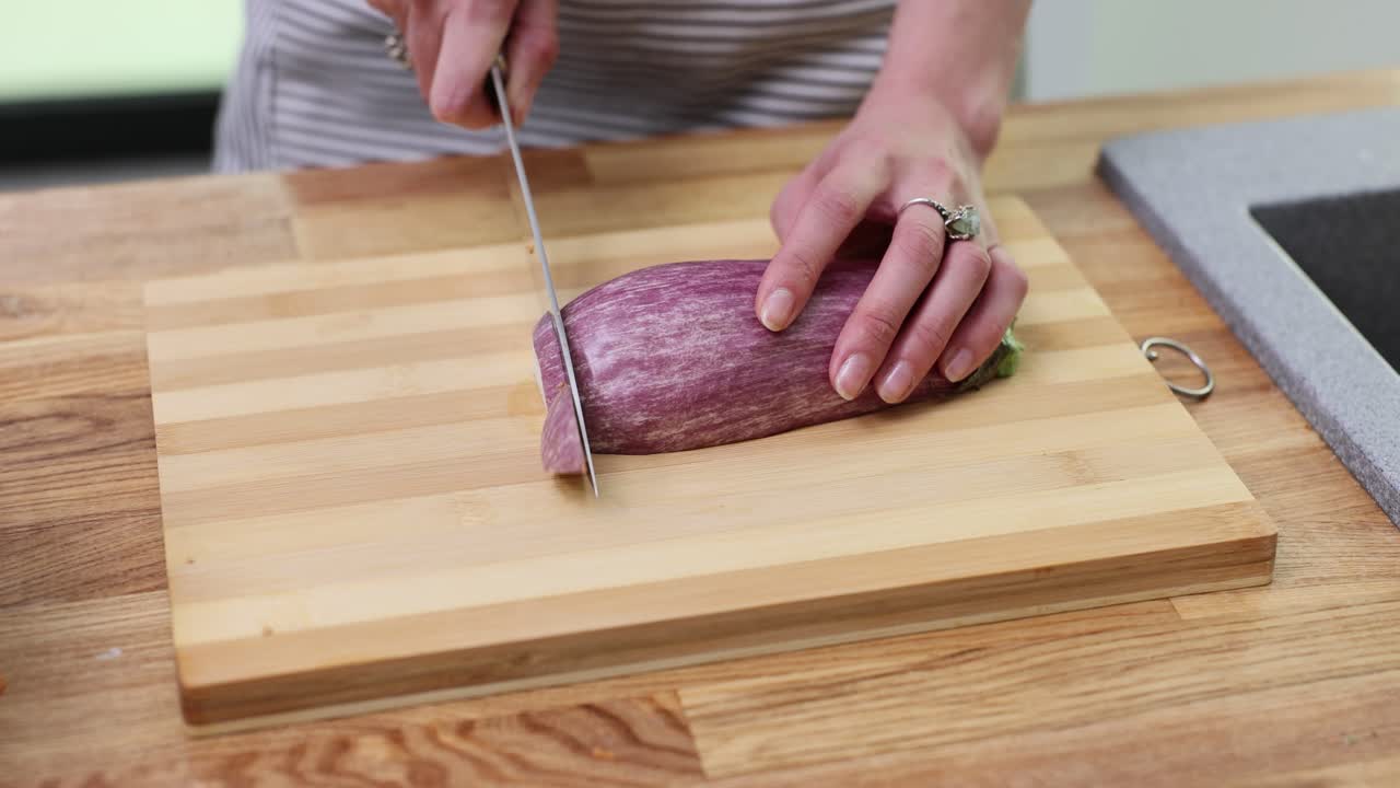Cutting eggplant on a wooden cutting board