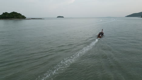 longtail boat on a tranquil bay with islands in the background