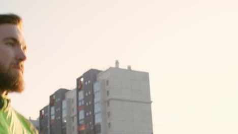 hombre en ropa deportiva corriendo por el paseo junto al río en la ciudad temprano en la mañana 1