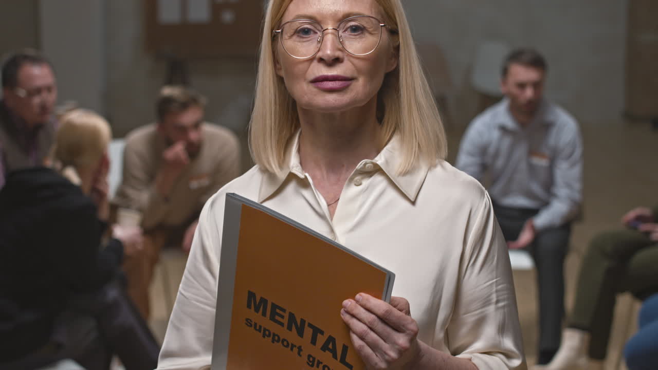 Female Psychologist Posing for Camera during Group Therapy Session