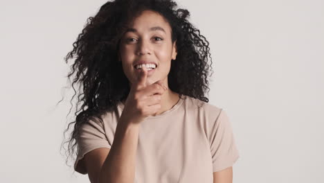 una mujer afroamericana sonriente sobre un fondo blanco.