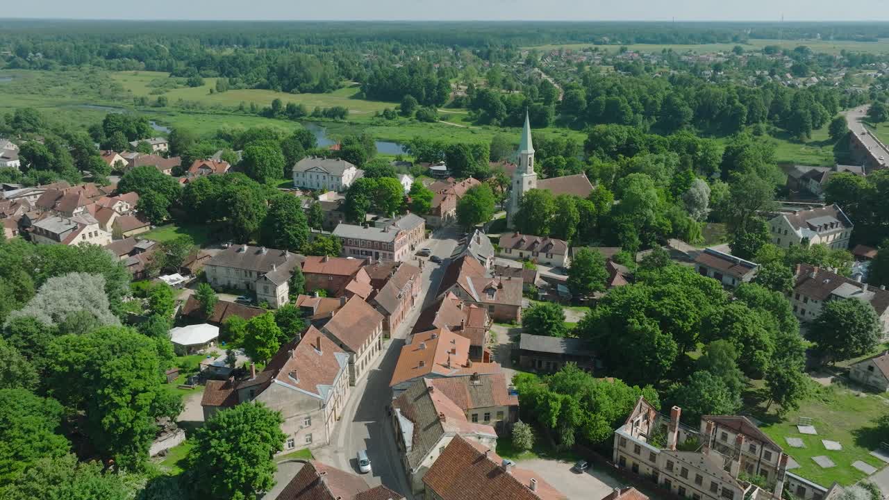 vista aérea del casco antiguo de kuldiga, casas con tejas rojas, día soleado de verano, destino de viaje, amplia toma de avión no tripulado avanzando, inclinándose hacia abajo