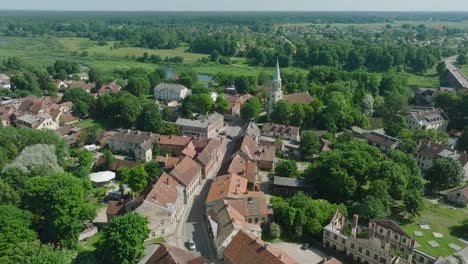 widok z powietrza na stare miasto kuldiga, domy z czerwonymi dachami, słoneczny letni dzień, miejsce podróży, szeroki strzał drona poruszający się do przodu, nachylony w dół