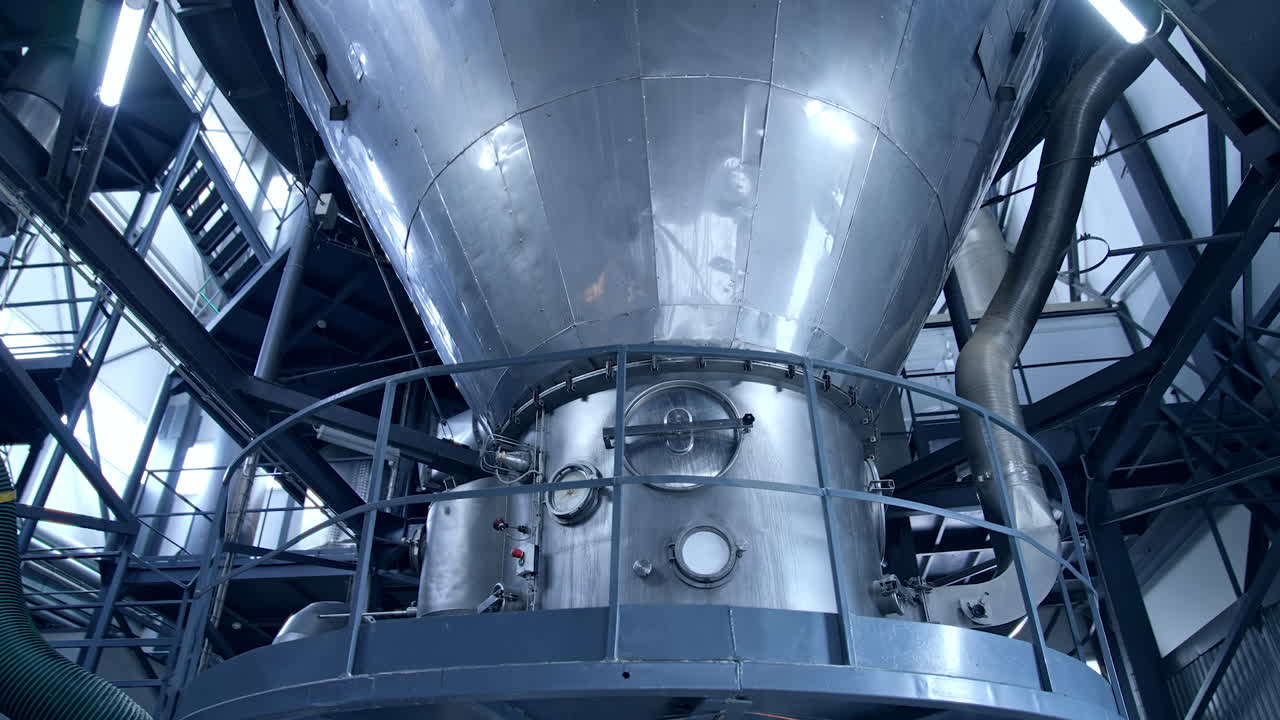 Large milk processing plant. Modern metal equipment inside the factory for production of dairy products. Dairy food production plant.