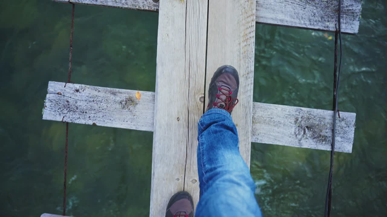 Person walking on a wooden bridge over water