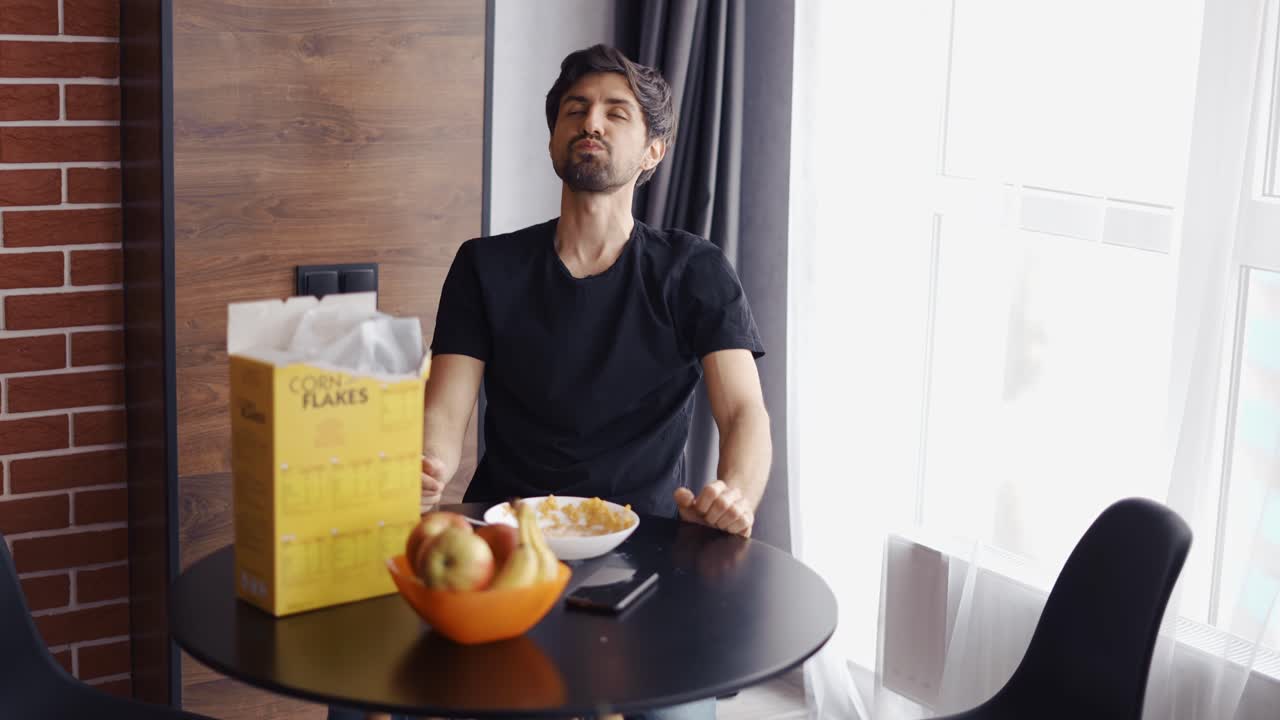 tipo tomando copos de maíz, mirando a la cámara