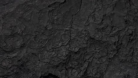 sharp and cracked volcanic rocks of deep black and grey color