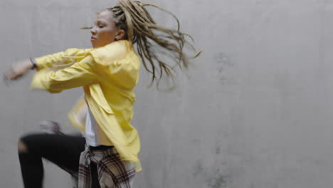 dancing woman young mixed race street dancer performing freestyle hip hop moves enjoying modern dance expression practicing in grungy warehouse wearing yellow jacket