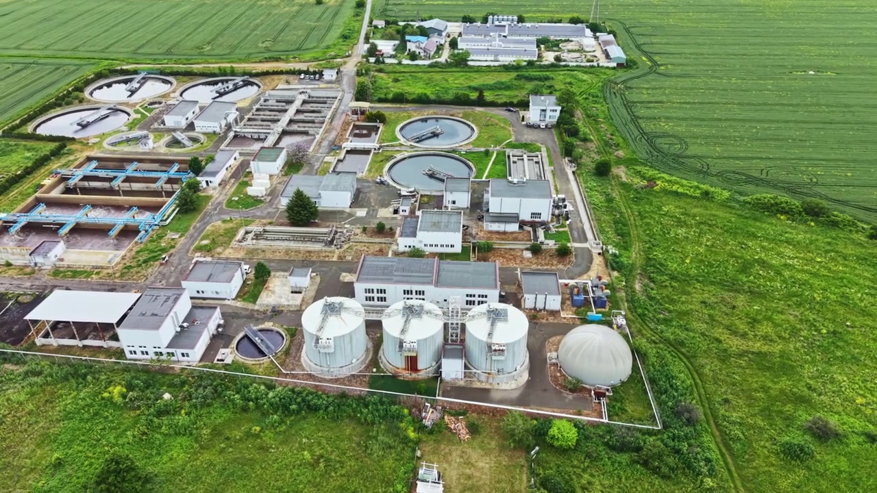 Overhead perspective displays environmentally mindful sewage treatment facility. High above shot emphasizes ecofriendly infrastructure supporting water purification processes