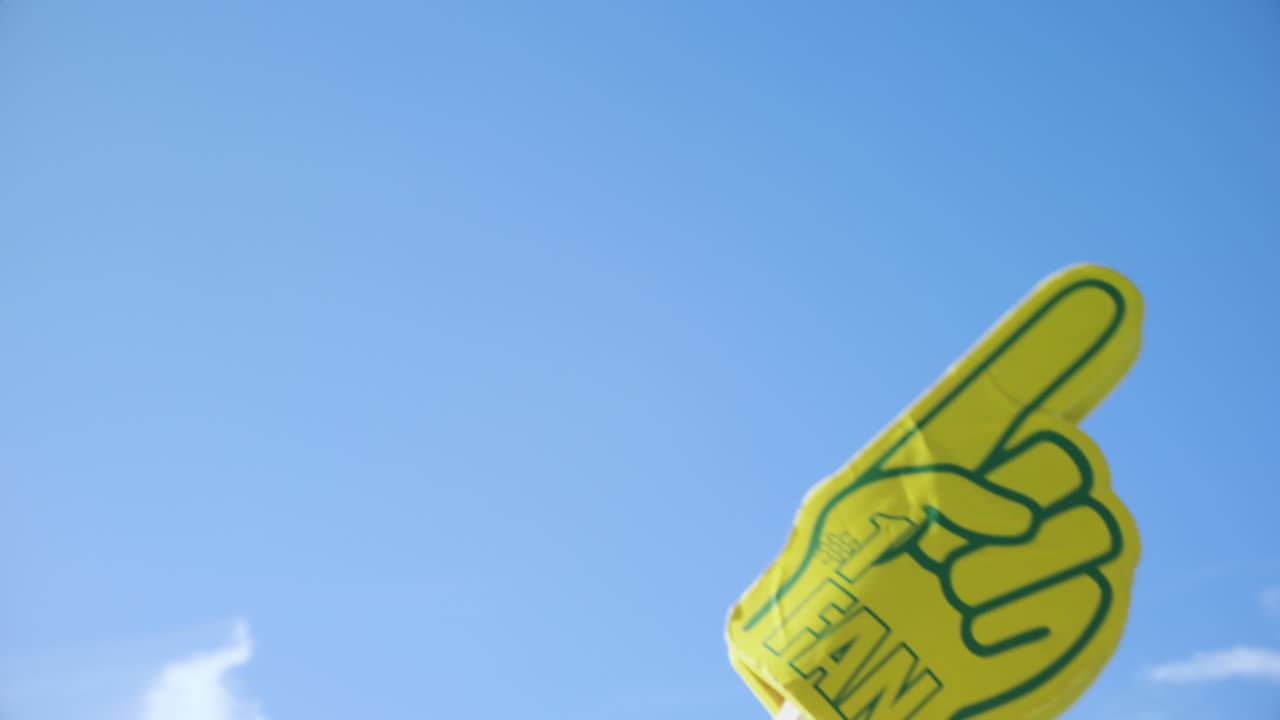 Foam hand waving against blue sky 4k
