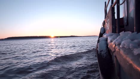 sunrise over a frozen river with a boat