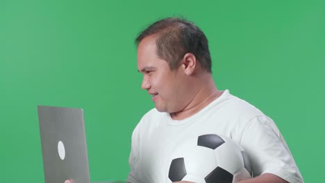 hombre viendo un juego de fútbol en una computadora portátil