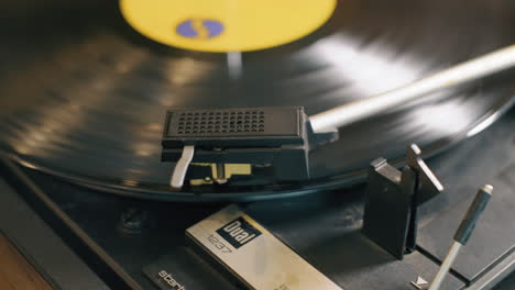 a male hand puts the needle onto a vintage lp vinyl record as the record spins