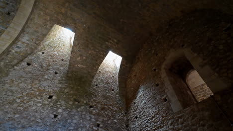 La-Luz-Del-Sol-Se-Filtra-A-Través-De-Las-Aberturas,-Iluminando-Los-Históricos-Muros-De-Piedra-Dentro-Del-Castillo