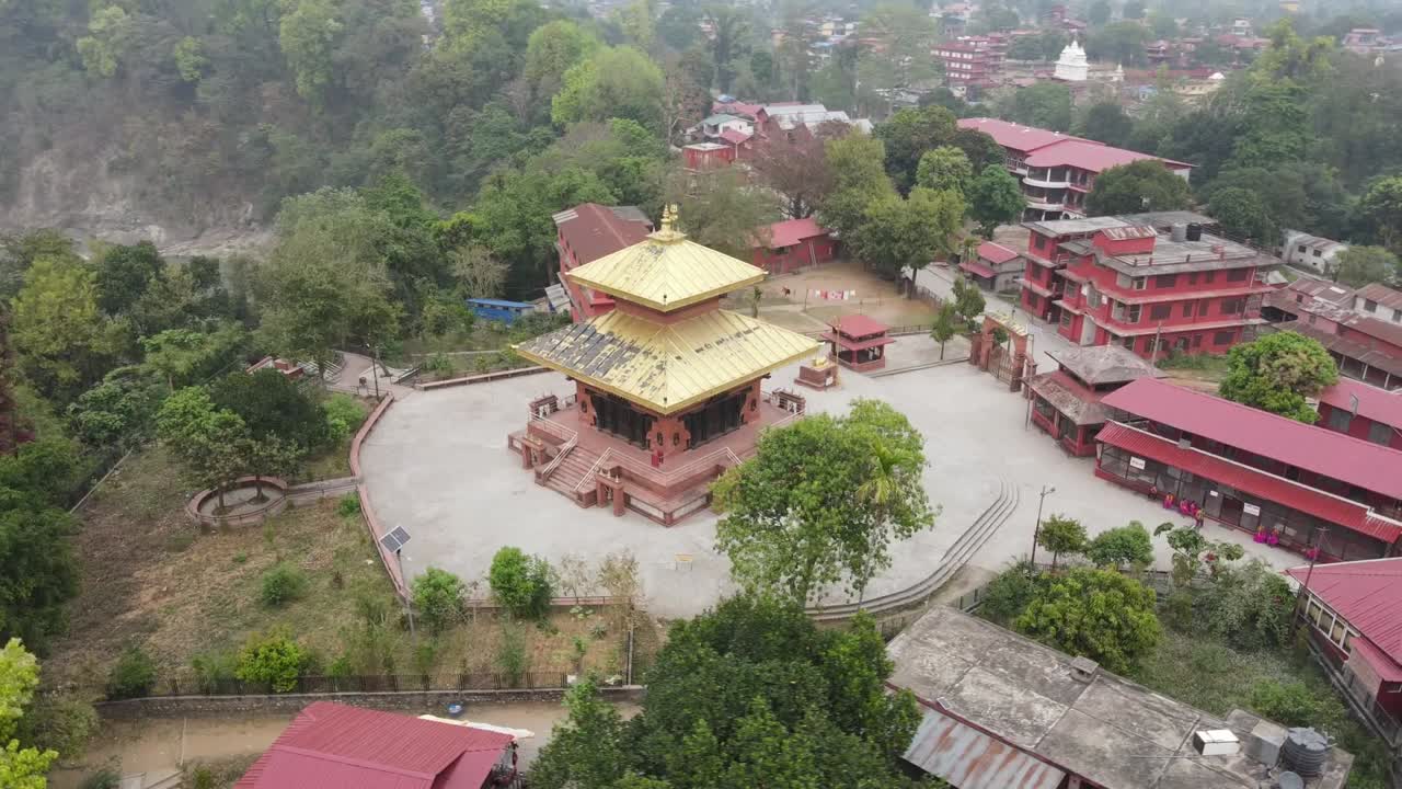 Drone footage gracefully circling Devdaha Temple in Chitwan, Nepal, showcasing sacred architecture and lush surroundings from all angles. Perfect for cultural, travel, and spiritual content