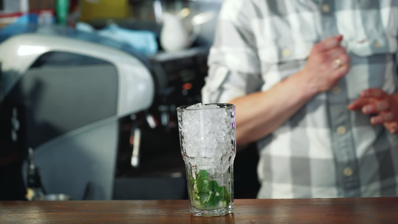 Process of preparing a cocktail. Mojito cocktail with lemon and mint on the bar. Close-up