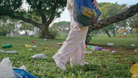 feet walking polluted park at discarded trash closeup. woman stepping garbage