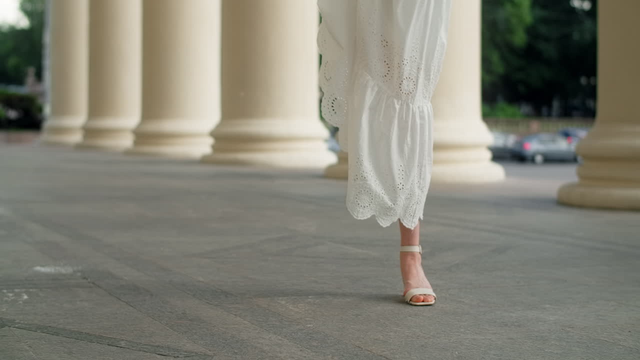Woman in a white dress and sandals outdoors