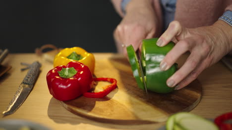 cutting colorful peppers on a wooden board