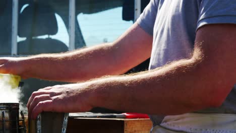 Beekeeper-preparing-bee-smoker-on-truck