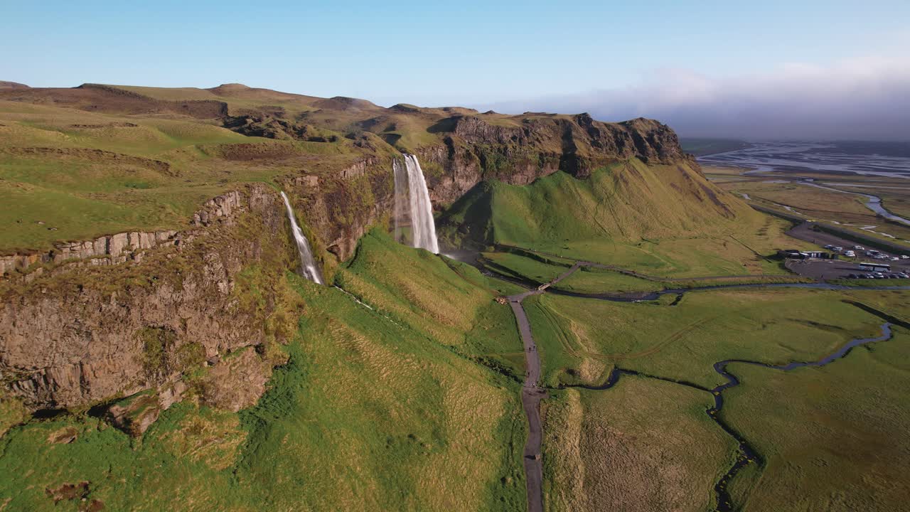 vista aérea de majestuosas cascadas en el verde paisaje islandés durante un día soleado