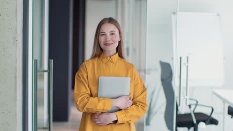 woman in a yellow shirt with a laptop