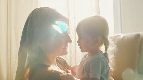 a mother and daughter smile at each other in a loving embrace