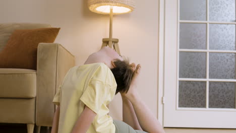 young teenager with down syndrome doing yoga posture at home