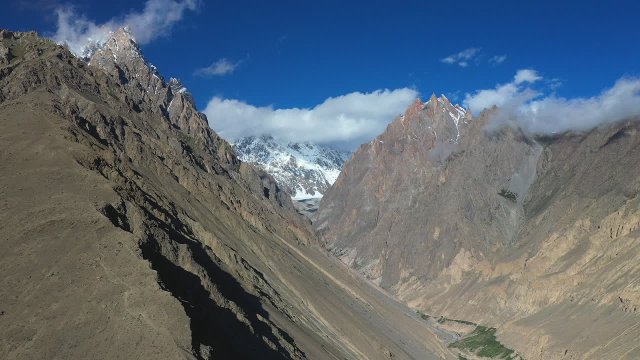 toma cinematográfica de drones de conos passu en hunza pakistán, pico tupopdan, picos montañosos cubiertos de nieve con acantilados escarpados, toma aérea amplia