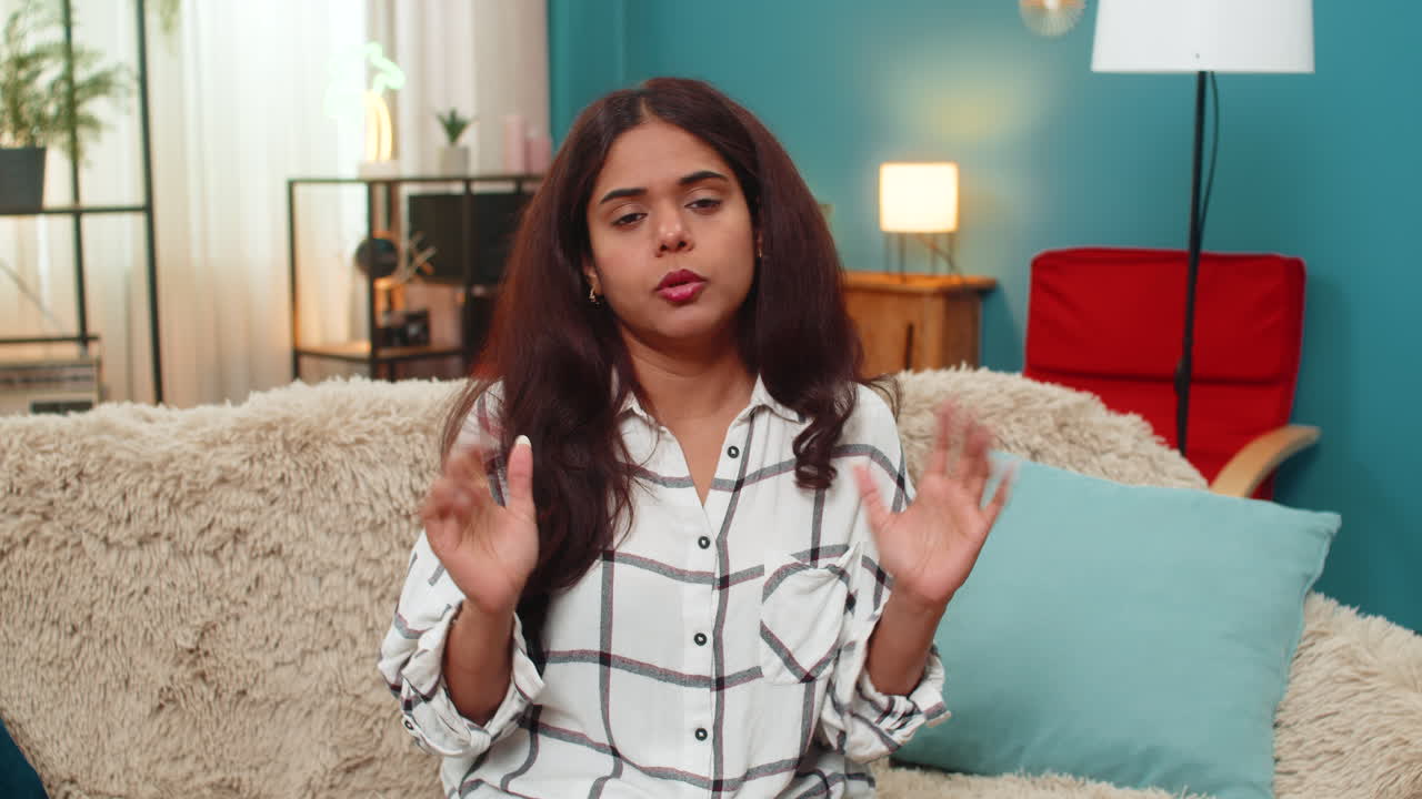 Indian woman gestures seriously looking at camera frustration disbelief angry expression indoor mood