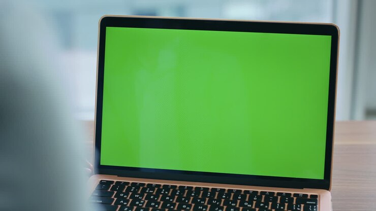 Nahaufnahme: Unbekannter Mitarbeiter betrachtet Mockup-Laptop an einem Steharbeitsplatz. Chroma-Key-Monitor.