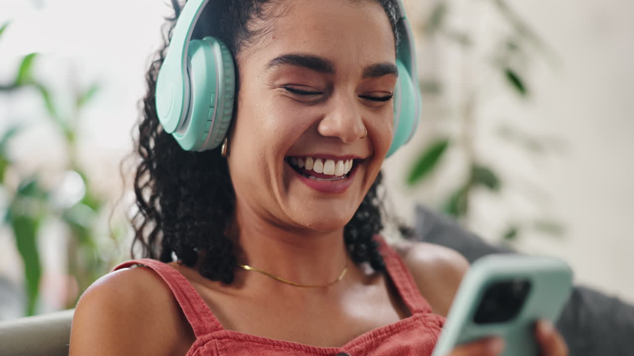 Donna che ride mentre usa il telefono con le cuffie