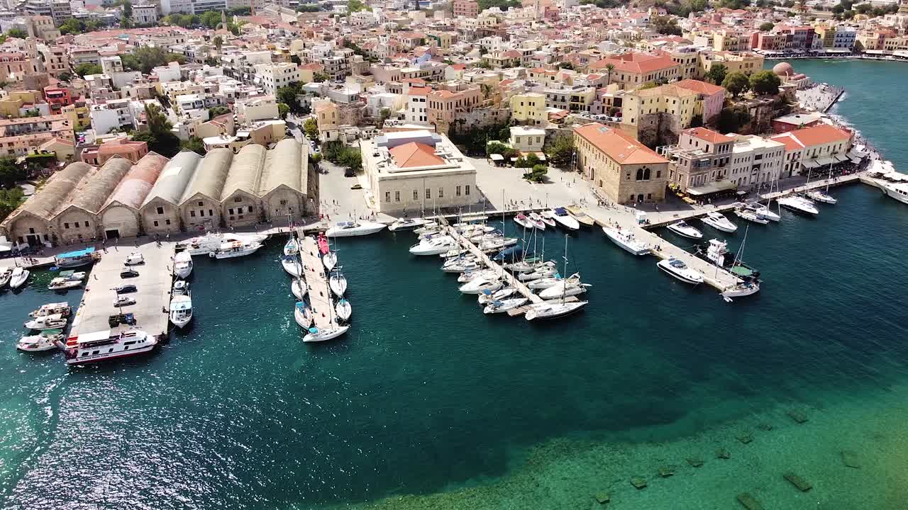 Calm water in pier with yachts and Chania in background, aerial view