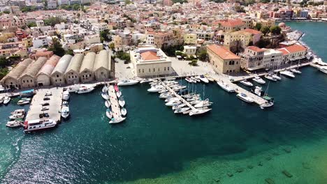 calm water in pier with yachts and chania in background, aerial view