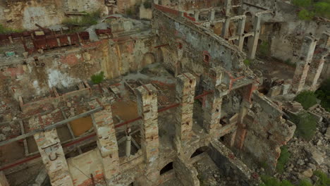 Laveria-Brassey,-Sardinia:-flying-over-the-ruins-of-the-buildings-of-this-old-abandoned-mine-on-the-island-of-Sardinia