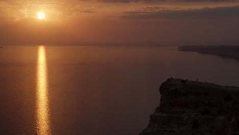 sonnenuntergang über dem ozean von einer klippe