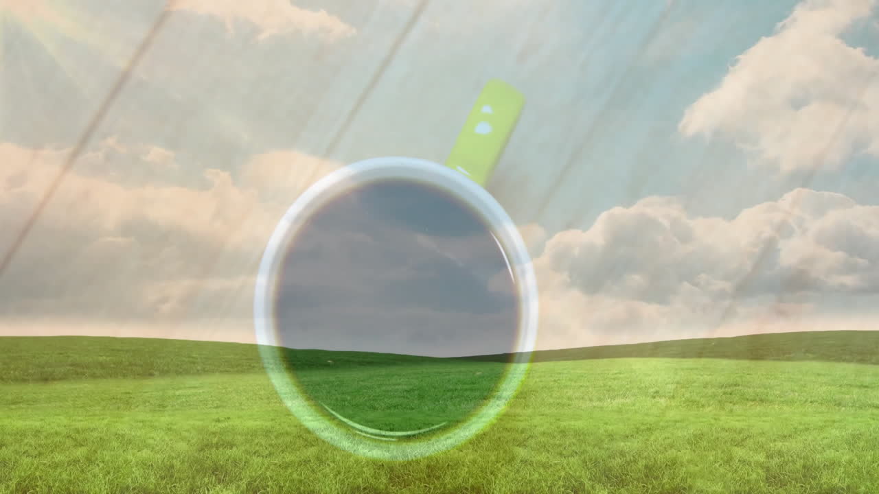 Green-handled ceramic coffee cup floating above lush green meadow, hills under soft sunlight rays
