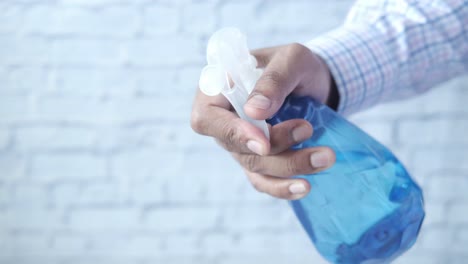 person holding a cleaning spray bottle