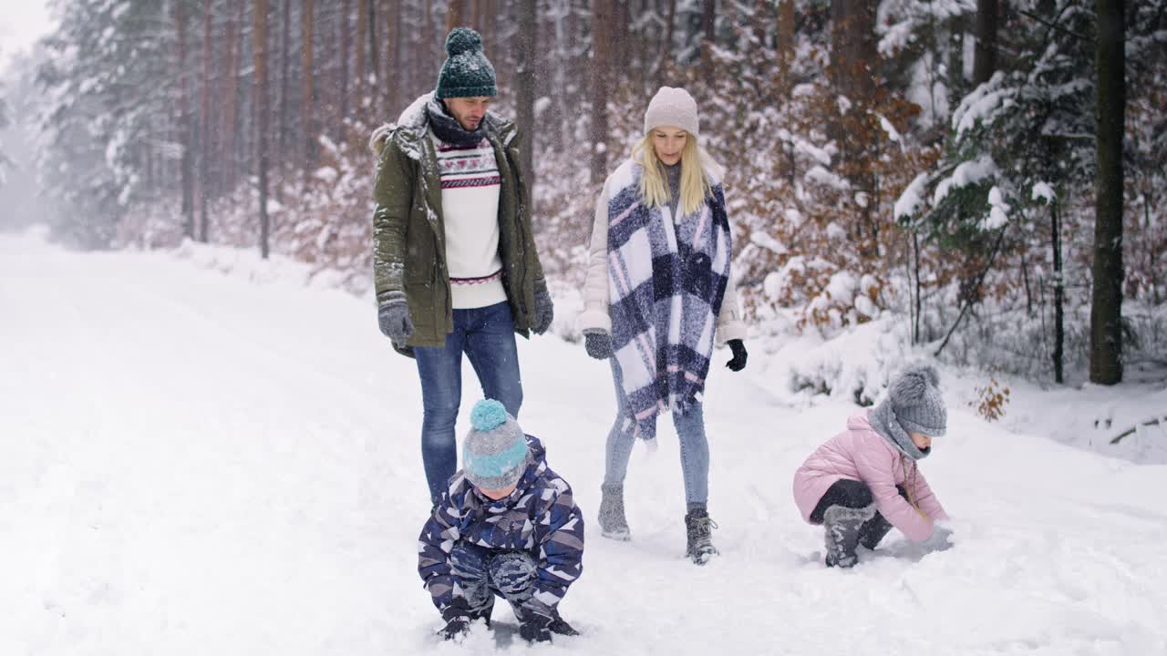 video de una familia con dos niños caminando en el bosque de invierno